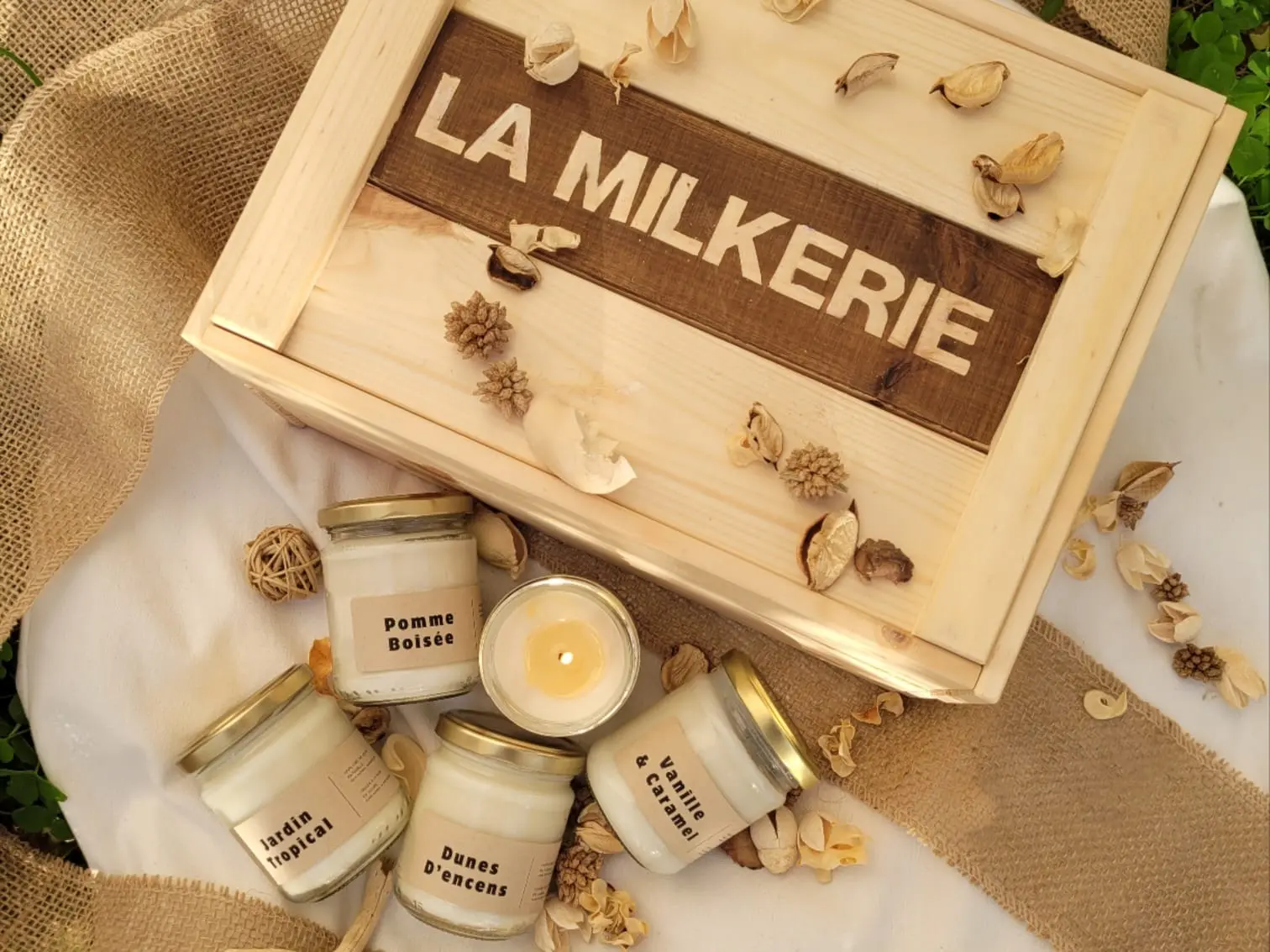Bougies artisanales de La Milkerie Coffret en bois La Milkerie avec quatre bougies artisanales parfumées Pomme Boisée, Jardin Tropical, Dunes d'Encens et Vanille & Caramel.